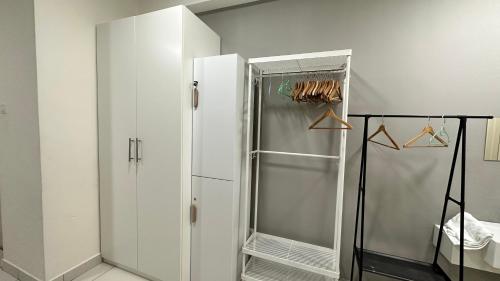 einen weißen Kühlschrank und eine Dusche im Zimmer in der Unterkunft Diamond Home Cozy at Arte Mont Kiara in Kuala Lumpur