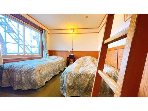 una camera con due letti e una finestra di Hakuba Pension Meteor - Vacation STAY 63315v a Hakuba