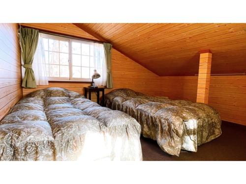 two beds in a room with a window at Hakuba Pension Meteor - Vacation STAY 63342v in Hakuba