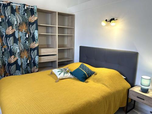 une chambre avec un lit avec un couvre-lit jaune dans l'établissement Maison cosy proche mer avec piscine chauffée, courts de tennis et patio - Bretignolles-sur-Mer - FR-1-224A-65, à Bretignolles-sur-Mer