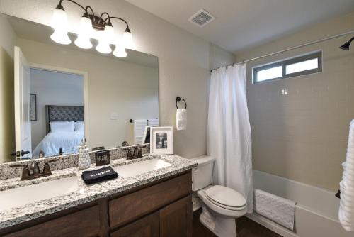 ein Badezimmer mit einem Waschbecken, einem WC und einem Spiegel in der Unterkunft New 3 Bedroom Vacation Home Lackland/Sea World/La Cantera in San Antonio