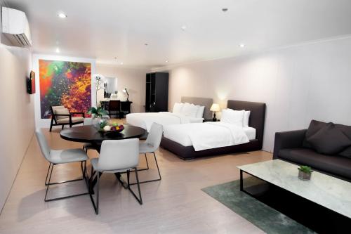 sala de estar con 2 camas y comedor en Green Sun Hotel, en Manila