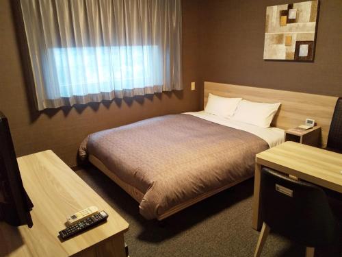 a hotel room with a bed and a window at Hotel Route-Inn Nishinasuno-2 in Nasushiobara