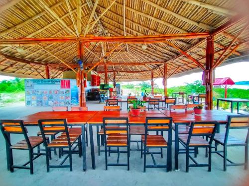 a group of tables and chairs under a roof at WJV BEACH RESORT MOALBOAL in Cebu City