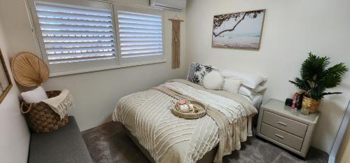 a small bedroom with a bed and a window at Casa del Sol Caloundra in Caloundra