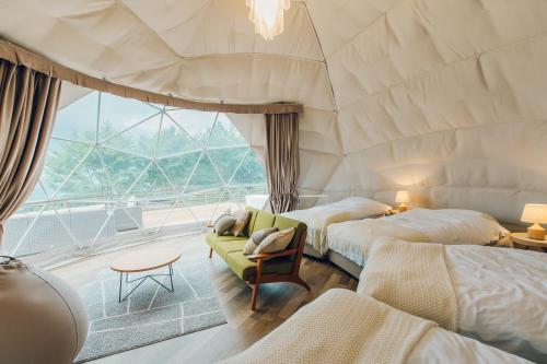 een kamer met 2 bedden en een groot raam bij LUONTE 霧の高原 Glamping 