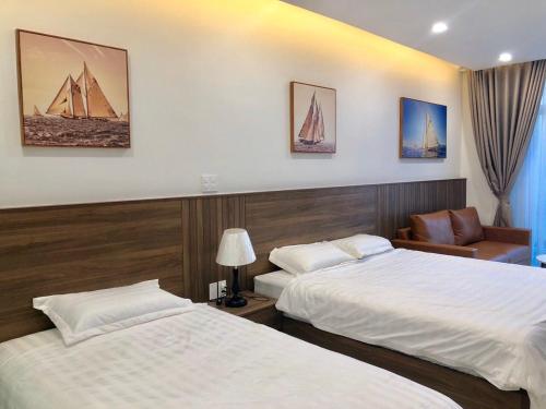 a hotel room with two beds and a chair at Hotel,Căn Hộ Mũi Né Sea link in Phan Thiet