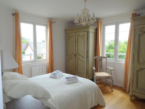 1 dormitorio con cama blanca, silla y ventanas en Beautiful apartment, 2 terraces, near the beach, Cayeux-sur-Mer, Baie de Somme, en Cayeux-sur-Mer