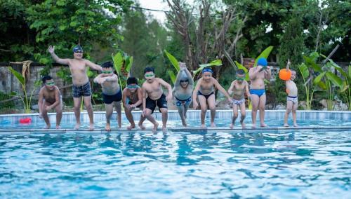 a group of people standing in a swimming pool at Khách sạn Đại Dương Diễn Châu - Nghệ An in Diễn Châu