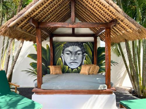 a bed in a room with a painting of a man at The Pleasure Dome in Amed