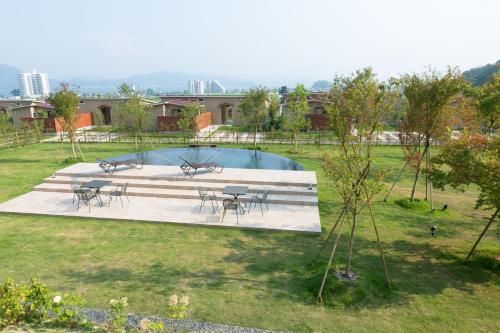 a pool with tables and chairs in a yard at Marinetopia The Suite in Miyazu
