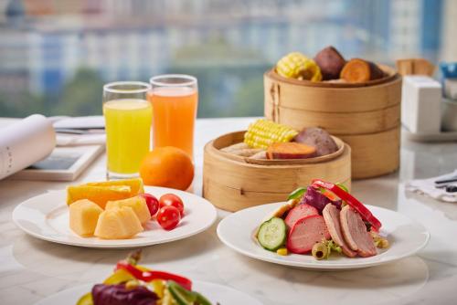 a table with plates of food and two glasses of orange juice at Four Points by Sheraton Shenzhen Bao'an in Shenzhen