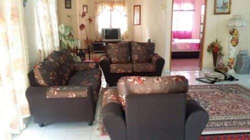 uma sala de estar com dois sofás e um sofá em Homestay Tambun Ipoh em Tambun