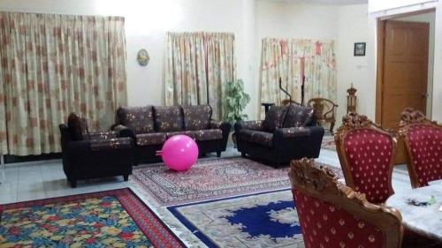 uma sala de estar com sofás e um balão rosa em Homestay Tambun Ipoh em Tambun