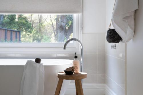 a bathroom with a tub and a sink and a window at Cooinda in Trentham