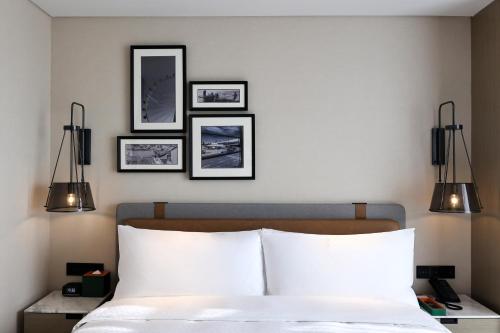 a bedroom with a bed with four pictures on the wall at Four Points by Sheraton Shenzhen Bao'an in Shenzhen