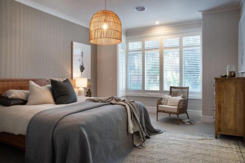 a bedroom with a bed and a lamp and a chair at Cooinda in Trentham