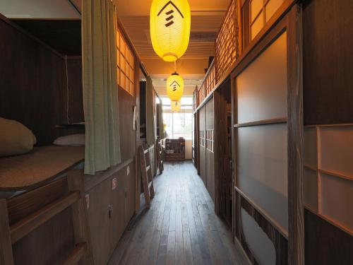 un corridoio vuoto con due letti e un lampadario di Yamagata Guesthouse山形ゲストハウス a Murayama