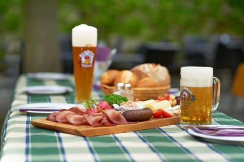 a table with a plate of food and two glasses of beer at Gasthof Gigl in Neustadt an der Donau