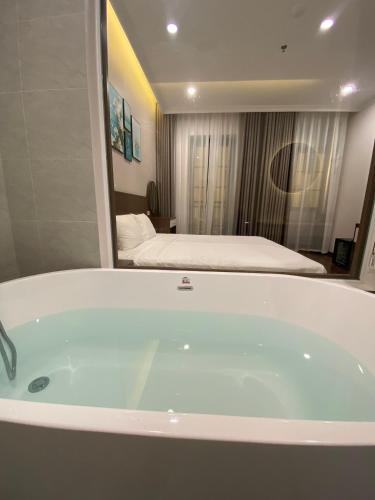 a bath tub in a room with a bedroom at MOONLIGHT HOTEL in Ha Long