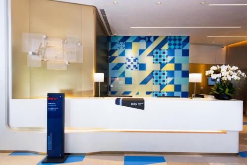 a lobby with a reception desk with flowers on the wall at Holiday Inn Express Macau City Centre, an IHG Hotel in Macau