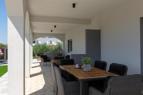 a dining room with a wooden table and chairs at Villa Kalani in Kaštela