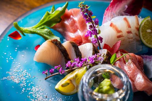 a blue plate of food with fish and fruit at Marinetopia The Suite in Miyazu