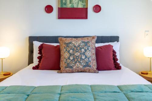 - un lit avec des oreillers rouges et bleus dans l'établissement Harmony Hideout 2 bed 2 bath, à Christchurch