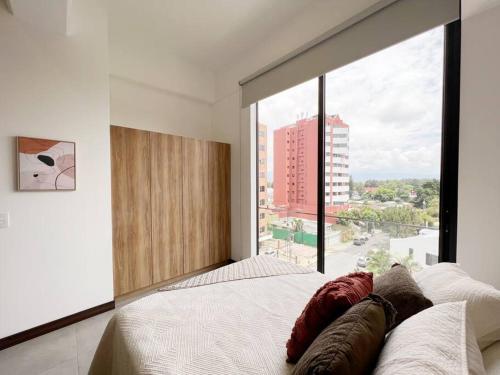 a bedroom with a large window with a large bed at Nuevo apartamento cercano al Aeropuerto gran vista in Guatemala