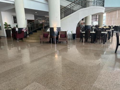 a dining hall with tables and chairs in a building at Oriental Crystal Hotel in Kajang