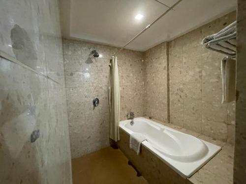 y baño con bañera y ducha. en Oriental Crystal Hotel, en Kajang