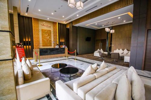 a lobby with a white couch and a table at Asialink Hotel Batam by Prasanthi in Nagoya