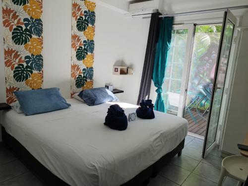 Un dormitorio con una cama con dos bolsas. en Lindsey Hôtel, en Saint-Pierre