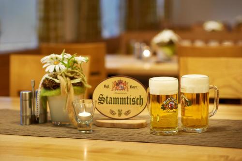 a table with two glasses of beer and a sign at Gasthof Gigl in Neustadt an der Donau