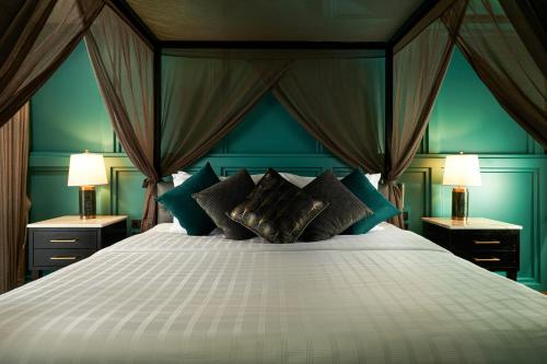 um quarto com uma cama grande e paredes azuis em The Moment Chiangmai em Chiang Mai