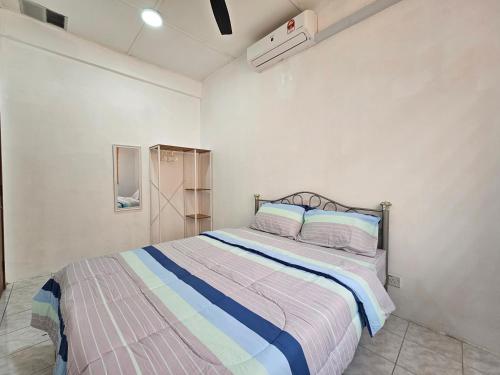 una camera con un letto con una coperta a righe di Sapphire Residence a Jenjarum