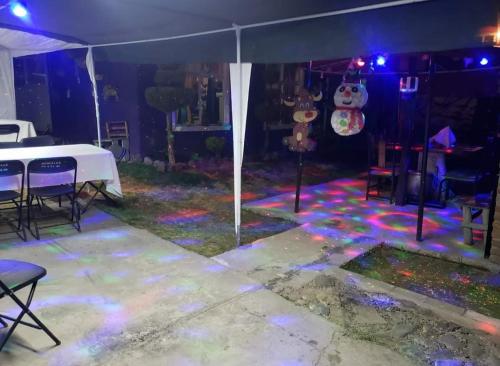 un escenario con una mesa blanca y luces púrpuras en Casa Chak, en Ciudad de México