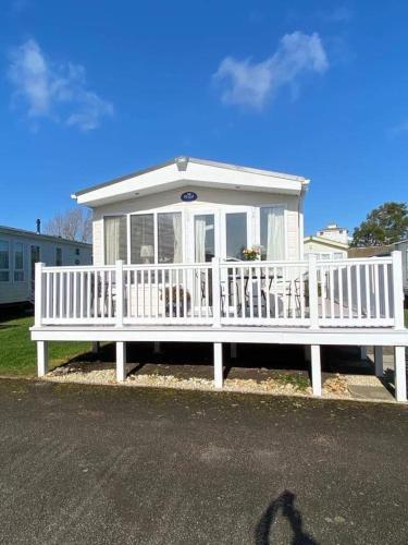 a white house with a large white porch at Rockley Park, Arne View in Hamworthy