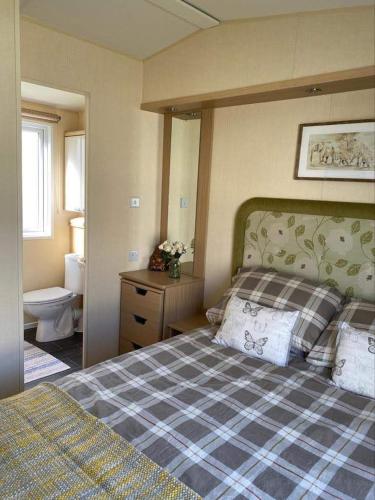 a bedroom with a bed and a sink and a toilet at Rockley Park, Arne View in Hamworthy