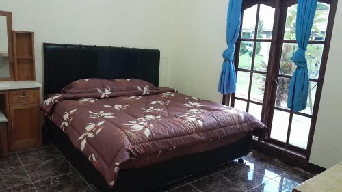 1 cama con edredón marrón en una habitación en Hotel Barbara en Tuk Tuk