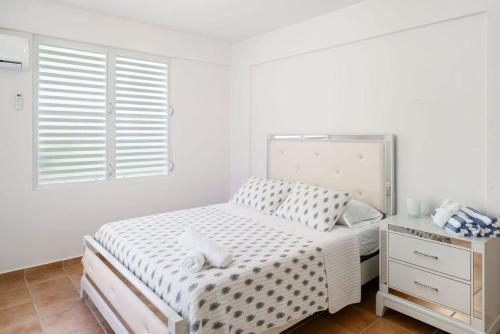 ein weißes Schlafzimmer mit einem Bett und einem Fenster in der Unterkunft Casa al Mare #3- 1 bdr - 4 min walk to Sandy Beach in Rincon