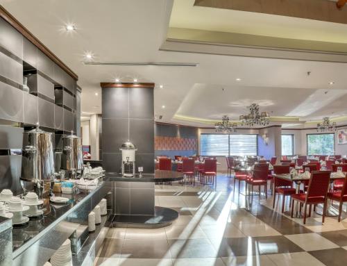 a restaurant with red chairs and tables in a room at Geneva Hotel in Amman