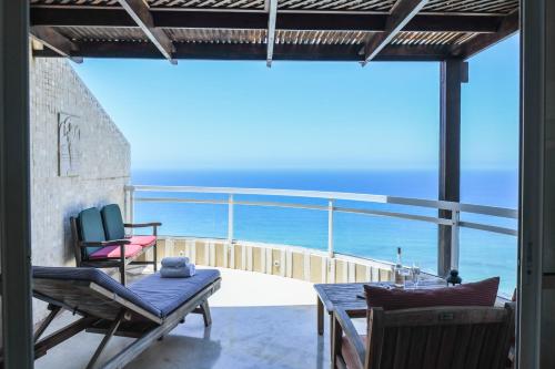 a balcony with a table and chairs and the ocean at Netanya Panoramic Sea-View Apt by Sea N' Rent in Netanya