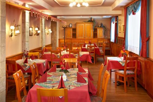 a restaurant with tables and chairs with red tablecloths at Gasthof Gigl in Neustadt an der Donau
