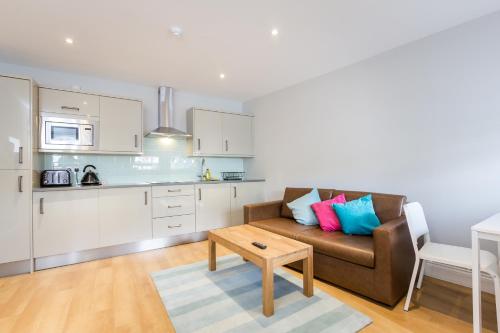 a living room with a couch and a table at The Lion Gate Mews in Kingston upon Thames
