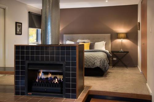 a bedroom with a fireplace in front of a bed at Daylesford Spa Villa 4 in Daylesford