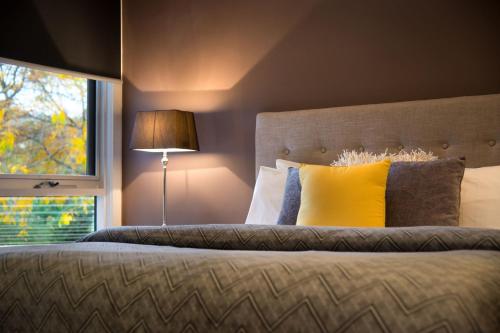 a bedroom with a bed with a yellow pillow and a window at Daylesford Spa Villa 4 in Daylesford