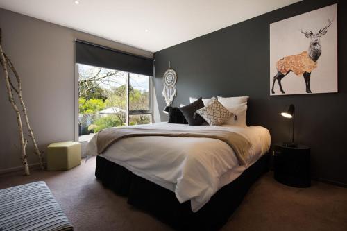 a bedroom with a bed with a deer on the wall at Daylesford Spa Villa 6 in Daylesford