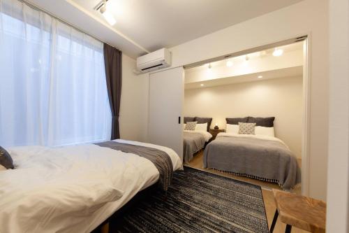een slaapkamer met 2 bedden en een spiegel bij LEGALAND Gakushuin Shita in Tokyo