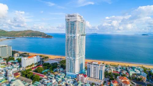an aerial view of a tall building next to the ocean at TMS Luxury Hotel in Quy Nhon
